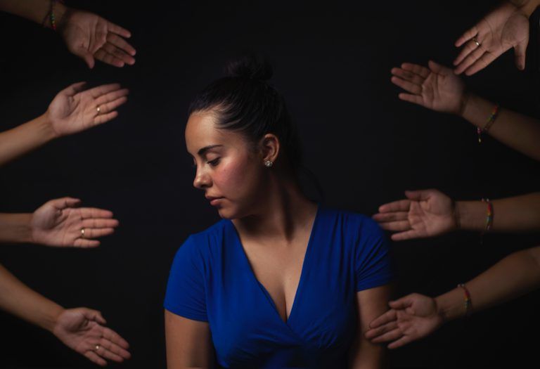 Woman surrounded by hands