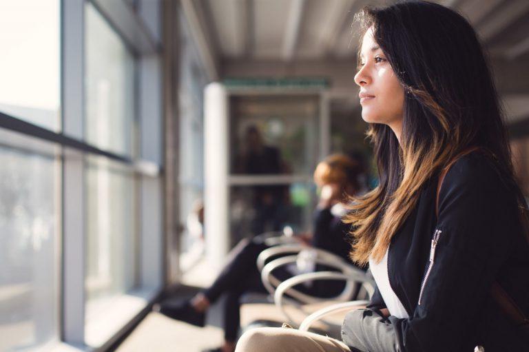 woman looking out window in airport